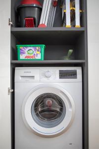 a white washing machine with a shelf above it at Apartment near city centre with parking place in Prague