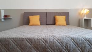 a bedroom with a large bed with two yellow pillows at Case Vacanza Marzano in Monopoli
