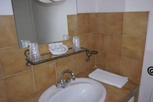 een badkamer met een wastafel en een spiegel bij Auberge des Seguins in Buoux