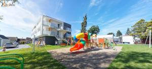 un parque infantil frente a una casa con tobogán en Xanadu Resort, en Sianożęty