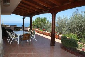 a patio with a table and chairs under a pergola at La Collina Capo d'Orlando in Capo dʼOrlando