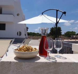 a table with a bowl of food and two wine glasses at Terrazza Sui Colli in Monopoli