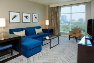 a living room with a blue couch and a large window at Hyatt Regency Atlanta Perimeter at Villa Christina in Atlanta