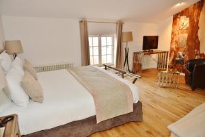 a bedroom with a large white bed and a television at Le Talluy in Taluyers