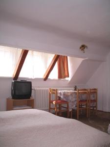 a bedroom with a bed and a table and a tv at Burg Eger in Eger