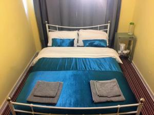 un letto con lenzuola bianche e blu e cuscini blu di prospect hill a Londra