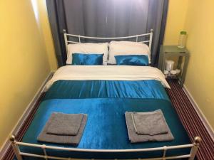 a bed with blue and white sheets and blue pillows at prospect hill in London