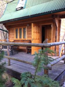 a cabin with a wooden deck with a piano at Sykytura in Sheshory
