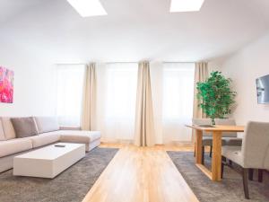 ein Wohnzimmer mit einem Sofa und einem Tisch in der Unterkunft SKY9 Apartments Margareten in Wien