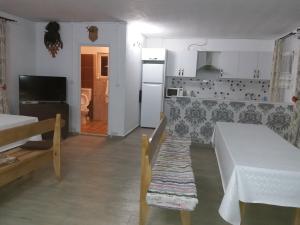 Il comprend une cuisine équipée d'une table blanche et d'un réfrigérateur. dans l'établissement Casa Alex, à Gîrda de Sus