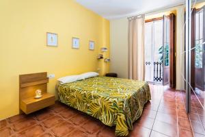 1 dormitorio con 1 cama con pared amarilla en Fun&Happy VLC Center, en Valencia