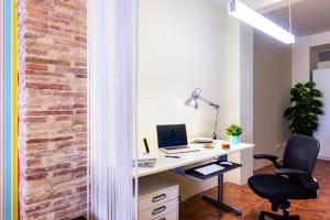 una oficina con una pared de ladrillo y un escritorio con ordenador en Fun&Happy VLC Center, en Valencia