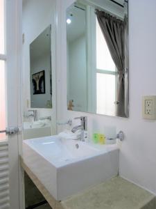 Baño blanco con lavabo y espejo en Hotel del Arte y Figura, en León