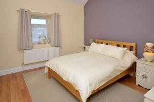 a bedroom with a large bed and a window at Cottage 312 - Ballyconneely in Ballyconneely