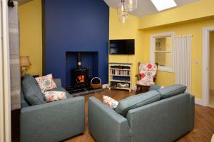 een woonkamer met 2 banken en een open haard bij Cottage 312 - Ballyconneely in Ballyconneely