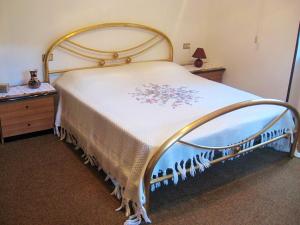 een slaapkamer met een groot bed en een witte deken bij Alla casa del cedro in Cavedago