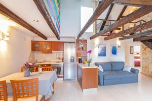 a kitchen and a living room with a blue couch at Apartment Bona Palace in Dubrovnik
