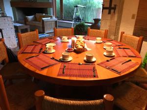 a wooden table with cups and plates of food on it at Hotel Boutique El Campirano in Amanalco de Becerra