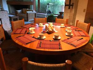 una mesa de madera con tazas y platos de comida. en Hotel Boutique El Campirano en Amanalco de Becerra