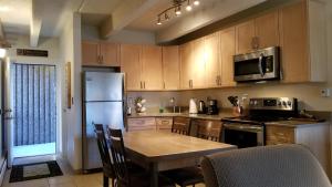 a kitchen with a table and a refrigerator at Heart of Frisco Condo in Frisco
