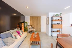 ein Wohnzimmer mit einem Sofa und einem Tisch in der Unterkunft 1bd apartment with garden Brugmann area in Brüssel