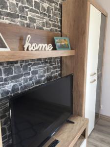 ein Wohnzimmer mit einem Steinkamin und einem TV in der Unterkunft FeWo Haus Emma OG in Löhnberg