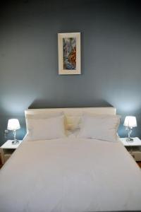 a bedroom with a large white bed with two lamps at Apartment 9 - City centre in Sibiu
