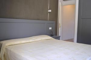 1 dormitorio con 1 cama con colcha blanca en Elbamar Lacona, en Lacona