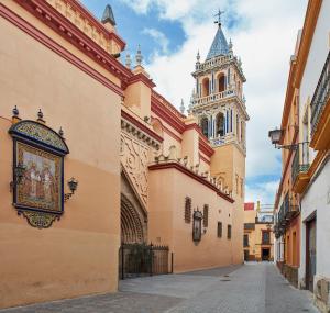a building with a clock tower and a street at Triana House in Seville +28 photos