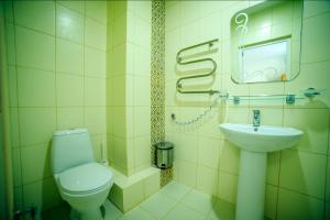 a bathroom with a toilet and a sink at Hotel Dombay in Gelendzhik
