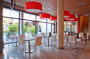 a restaurant with tables and chairs and red chandeliers at Travelodge Torrelaguna in Madrid