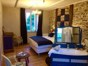 a bedroom with a bed and a sink and a tub at Les Chambres du Mad in Henvic