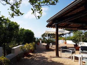 a patio with tables and chairs and an umbrella at Villa del Sogno in Parghelia