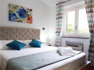 um quarto com uma cama com almofadas azuis e uma janela em Villa del Sogno em Parghelia