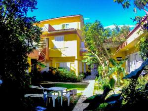 a yellow building with a table and chairs in a yard at Casas Amarelas in Florianópolis