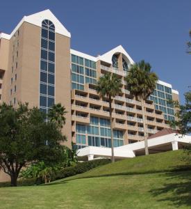 un gran edificio con palmeras delante en South Shore Harbour Resort and Conference Center en League City