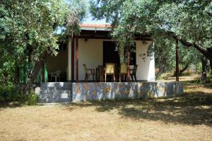 a cottage with a table and chairs in front of it at Ktima Elia in Skala Sotiros