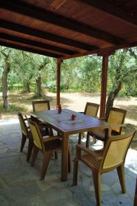 einen Holztisch und Stühle auf einer Terrasse in der Unterkunft Ktima Elia in Skala Sotiros