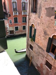 a view of a canal with green water and buildings at Penthouse Of Venice in Venice