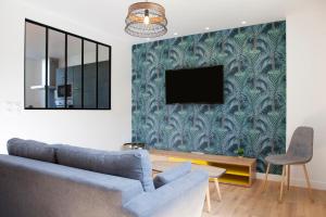 a living room with a blue couch and a tv at Résidence Maréchal Leclerc in Laval