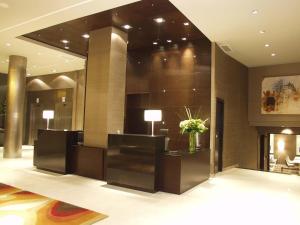 a lobby of a hotel with a reception desk and flowers at Hotel Conqueridor in Valencia