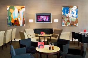 a waiting room with tables and chairs and paintings at Hotel Conqueridor in Valencia