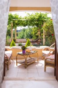 een patio met een tafel en stoelen en een prieel bij Madonna Guest House in Dubrovnik