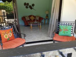 sala de estar con 2 sillas y sofá en The Room Cozy-Nest, en Santiago de los Caballeros