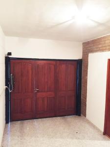 garaje con 2 puertas de madera en una habitación en Casa Nuova Depto CERO en Villa María