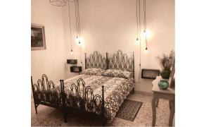 una camera con letto e testiera in ferro battuto di B&B Miseno23 a Bacoli