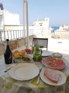 een tafel met borden en een glas wijn bij Dimora La Nicchia in Polignano a Mare