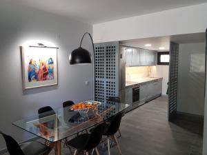 una cucina e una sala da pranzo con tavolo e sedie in vetro di By the Beach a Almancil