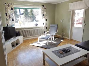 een woonkamer met een tv en een stoel en een tafel bij Villa Tall in Vidsel