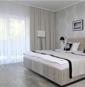 a bedroom with a large bed and a large window at Willa Cicho Sza in Pobierowo